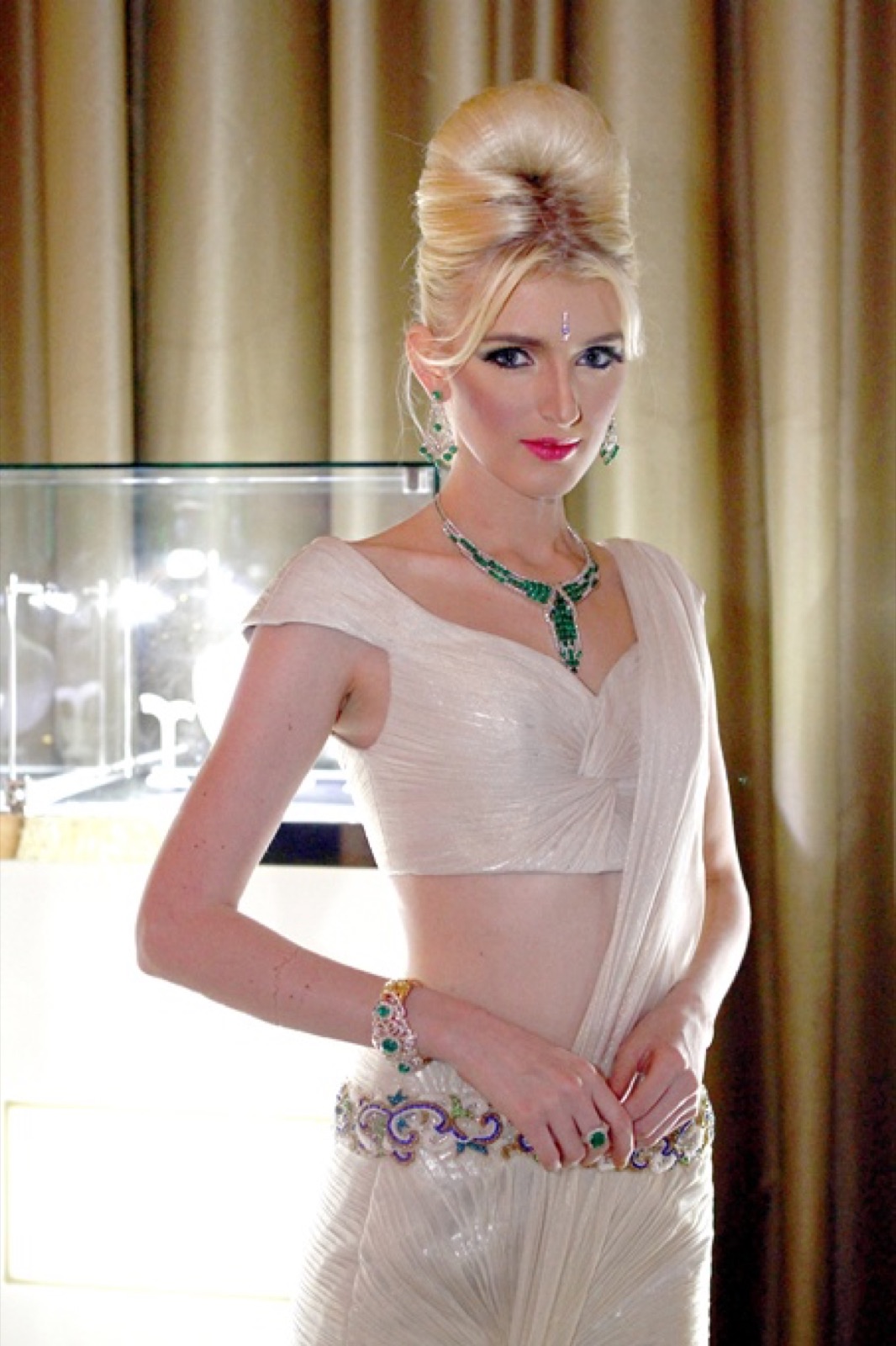 A model wearing an emerald suite: necklace, earrings, bracelet and ring