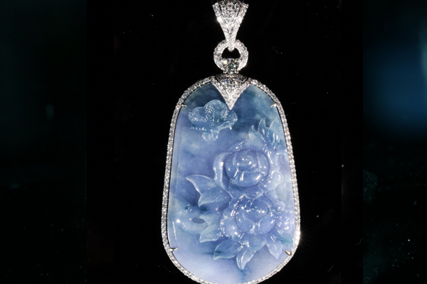 A lavender jadeite plaque carved with peonies, framed by a fine line of diamonds.