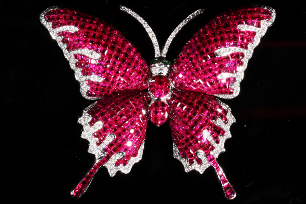 A butterfly poised in rubies and pavé diamonds.