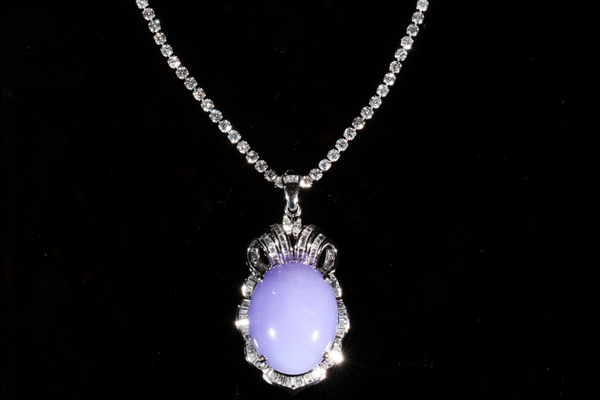 Lavender jade suspended within a fine lattice of diamonds.