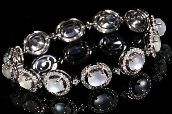 A line bracelet of luminous icy cabochons, each within its own diamond surround.