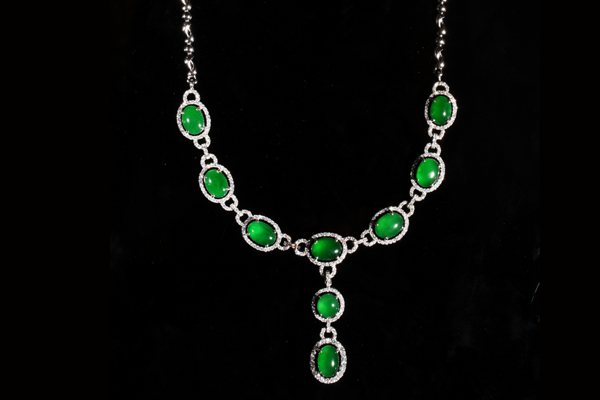 Nine vivid green jadeite cabochons linked by diamonds