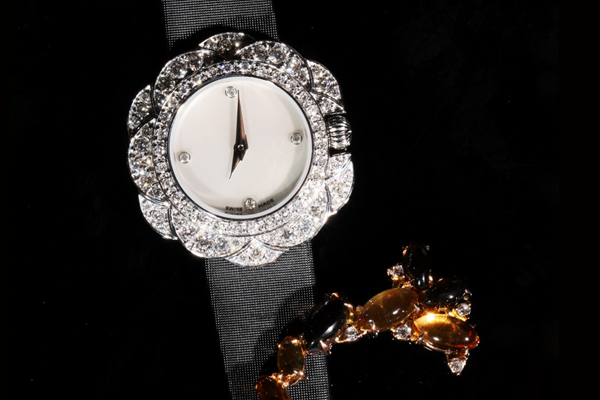A jewelled timepiece, its case composed of diamond petals, on a satin strap.