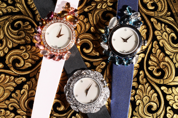 Jewelled timepieces at rest on gold brocade.